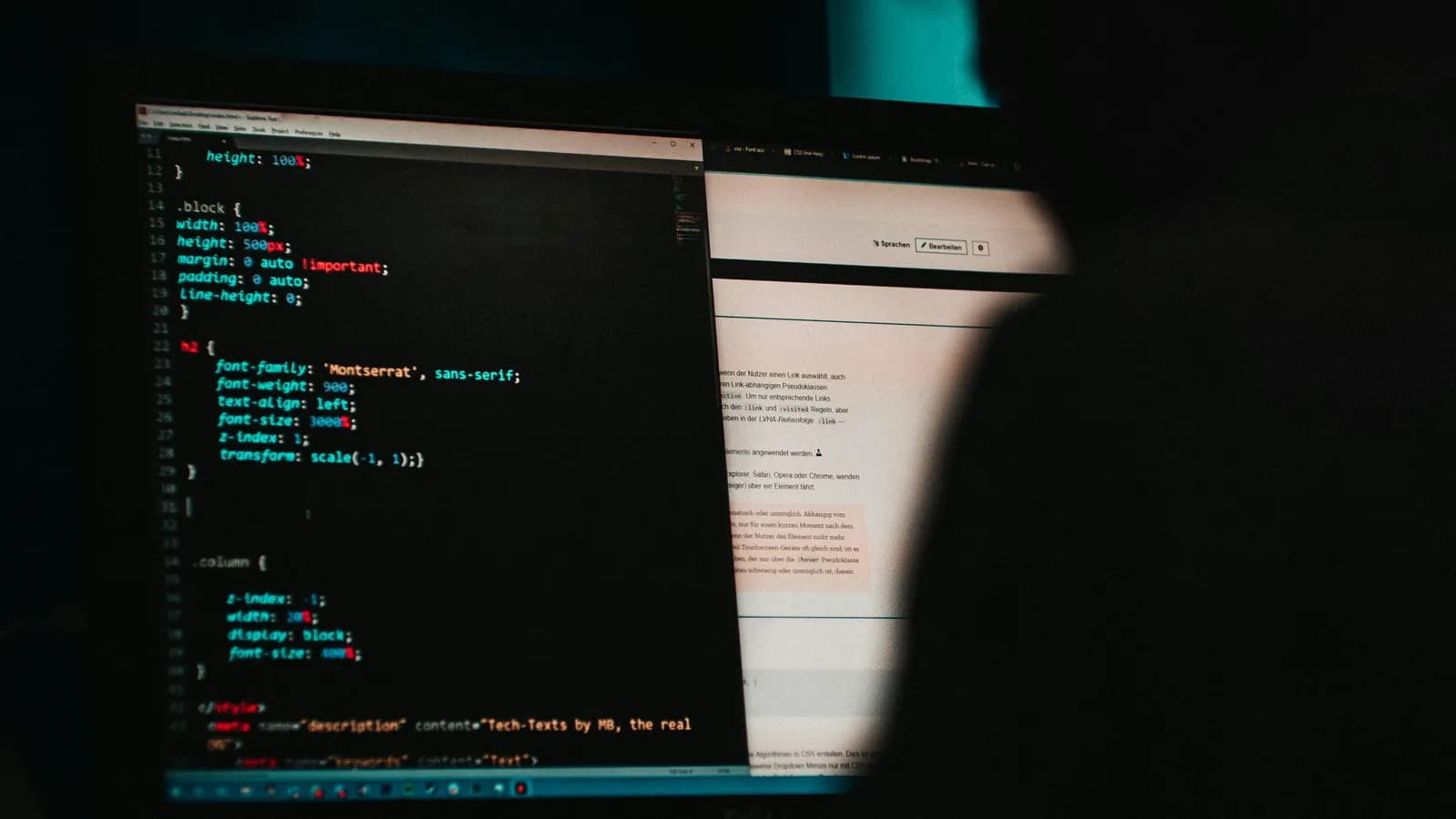 Écran affichant du code source et un navigateur dans une pièce sombre